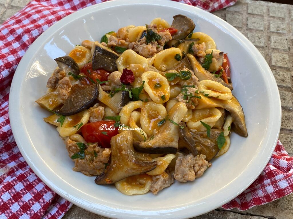 Orecchiette con Salsiccia, Funghi “Cardoncelli” e Pomodorini: un primo piatto Pugliese ricco di profumi, gusto autentico e tradizione. Una ricetta che conquista al primo assaggio.